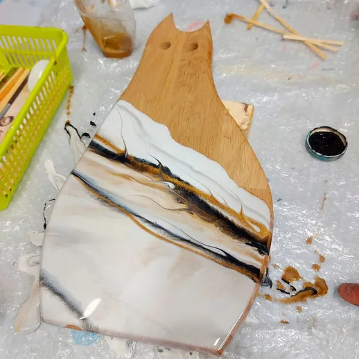 Фартук из дерева с эпоксидной смолой в процессе творчества на столе