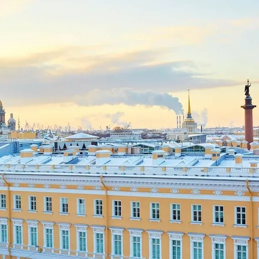 Зимний закат над Санкт-Петербургом, вид на небо и исторические здания города во время снежной погоды