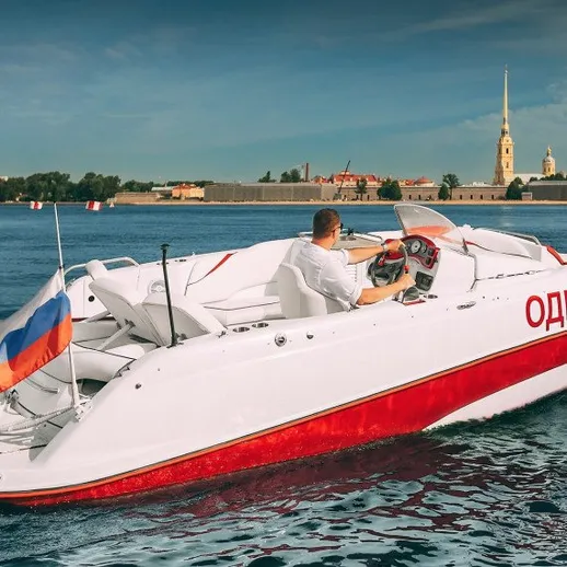 Рыбак управляет моторной лодкой у берегов Санкт-Петербурга в ясный день