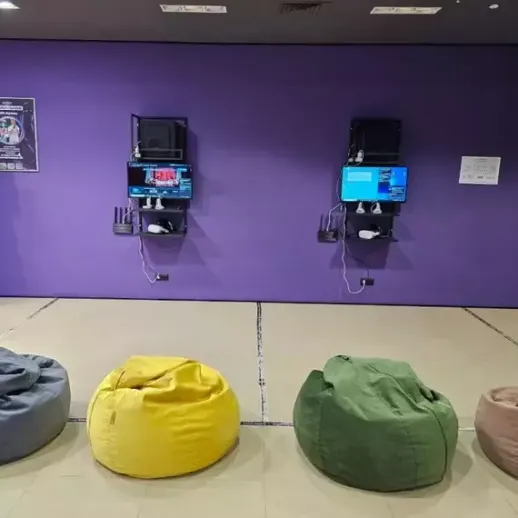 Уютная комната с пуфами для отдыха и экраном для игр в современном пространстве