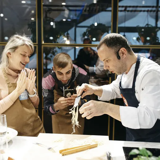 Кулинарный мастер-класс в уютном кафе, где шеф-повар делится секретами приготовления блюд