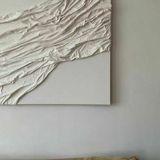 Современное абстрактное искусство на стене комнаты с нейтральными тонами и мягким диваном