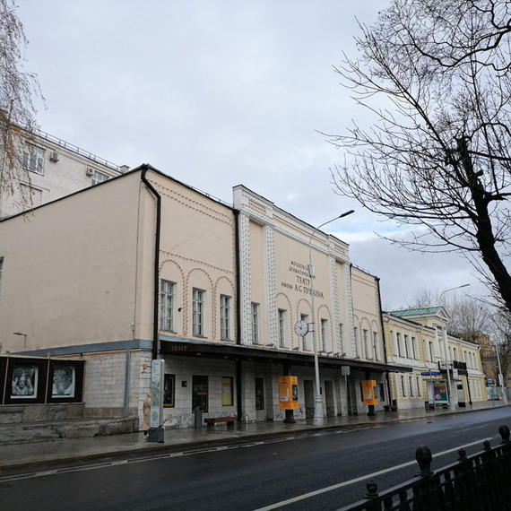 Здание театра на улице в Москве в серый осенний день с листопадом и пустой проезжей частью. Фото 12