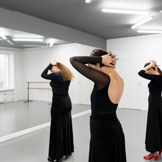 Три bailarinas в черных платьях готовятся к выступлению в танцевальной студии в утренний час. Фото 4