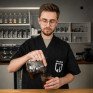 Кофейная чашка с красивым латте-артом на фоне кофейных зерен на деревянном столе - превью 1