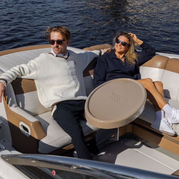 Два человека отдыхают на лодке во время поездки по реке в солнечный день