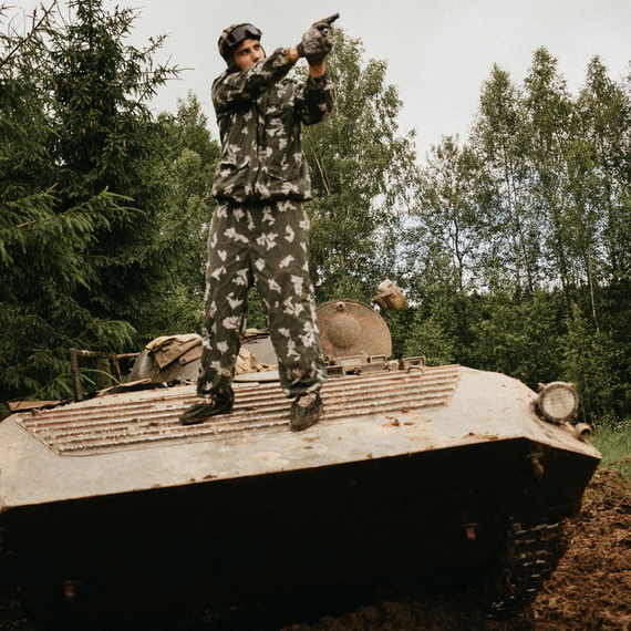 Военный солдат в камуфляжной форме стреляет с бронетранспортера в лесной местности. Фото 35