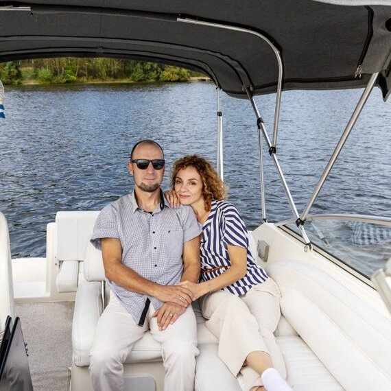 Человек и женщина отдыхают на лодке среди воды и зелени. Главное фото