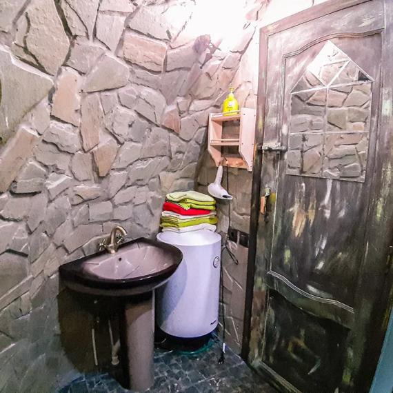Уютная ванная комната с каменной отделкой и современной сантехникой в загородном доме. Фото 15
