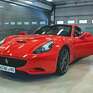 Ярко-красный спортивный автомобиль Ferrari в гараже с открытой дверью и ровным полом - превью 1