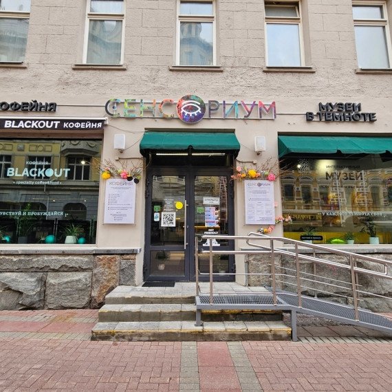 Кофейня и музей на улице, расположенные в центре города, с яркими вывесками и уютной атмосферой для гостей. Фото 8