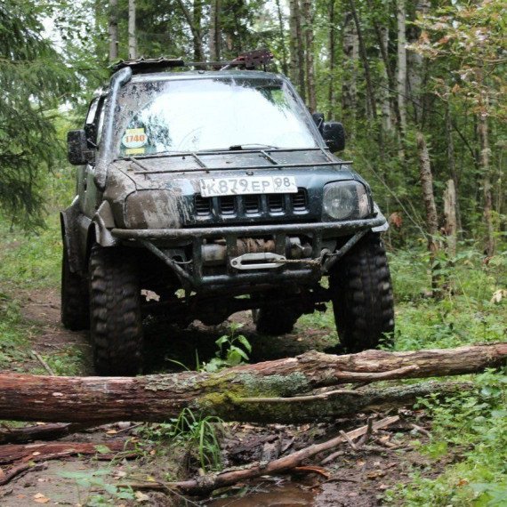 Внедорожник преодолевает препятствия в лесу