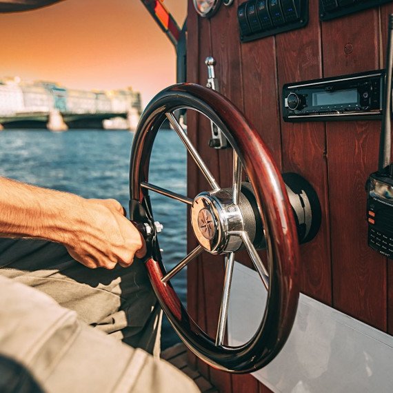 Капитан управлял лодкой на реке в солнечный день с красивым видом на город