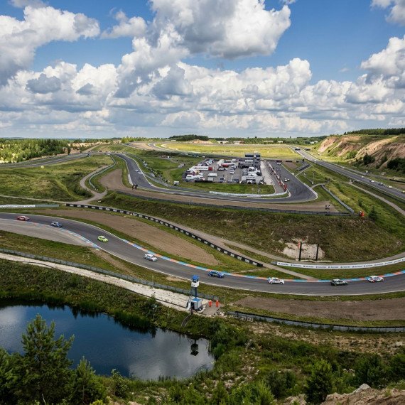 Зрелище автогонок на трассе с облаками и природой