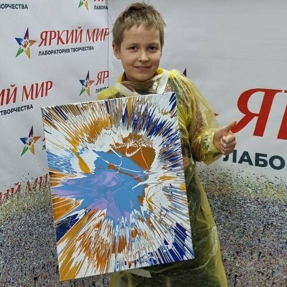 Мальчик с картиной в ярких цветах на выставке творчества в лаборатории Яркий Мир. Фото 11