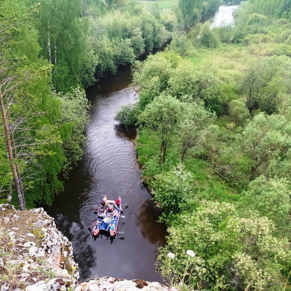 Сплав по реке в живописной местности с зелеными берегами в солнечный день