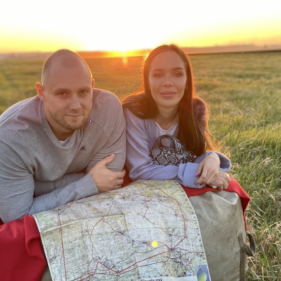 Пара на лужайке с картой на закате, наслаждаясь природой и отдыхая вдали от городских забот. Фото 5