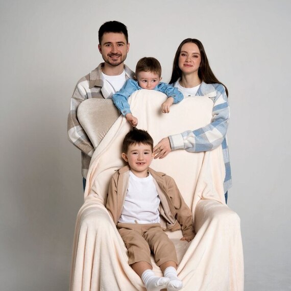 Счастливая семья наслаждается зимними праздниками в уютной обстановке с новорожденным ребенком и рождественской елкой. Главное фото