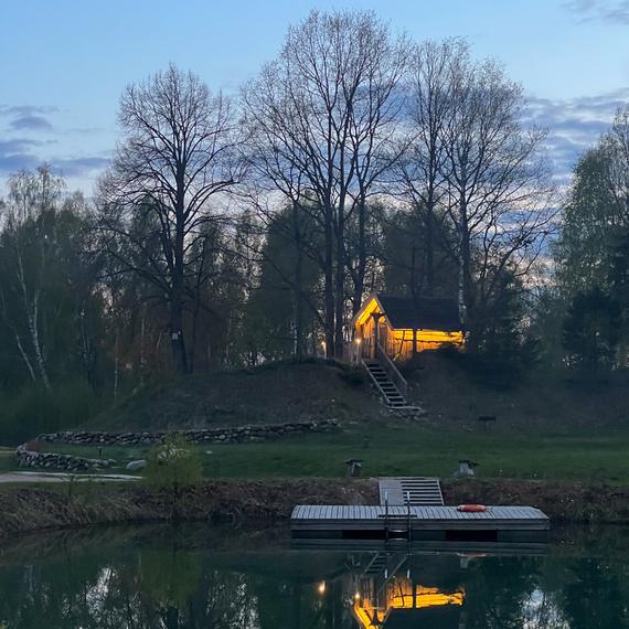 Небольшая дача на берегу озера в вечернее время с отражением в воде. Фото 24