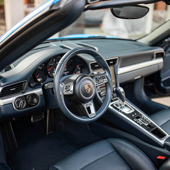 Внутри спорткара на месте водителя в солнечную погоду