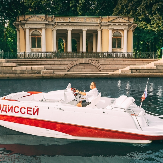 Моторная лодка Одиссей плывёт по Неве рядом с Зимним дворцом в Санкт-Петербурге. Главное фото