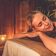 Женщина отдыхает на массажном столе в спа-салоне в вечернее время - превью 5