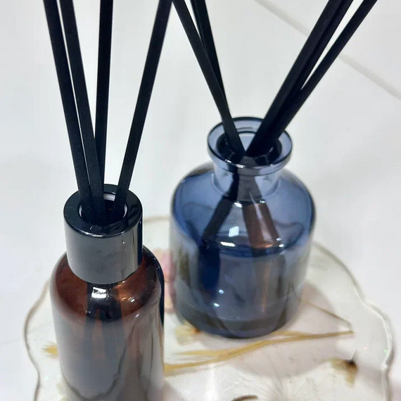 Два контейнера с эфирными маслами стоят на подставке в интерьере