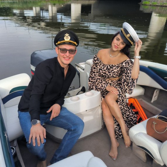 Молодые люди на лодке у моста в летний день