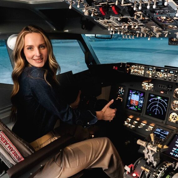 Женщина находится в кабине пилота и управляет самолетом на аэродроме Женщина находится в кабине пилота и управляет самолетом на аэродроме