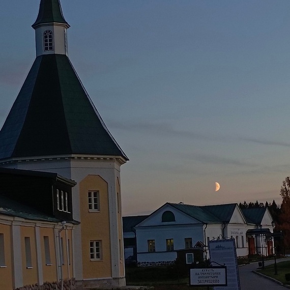 Ночная панорама старинной церкви и окружающих зданий в тихом поселке на закате. Фото 13