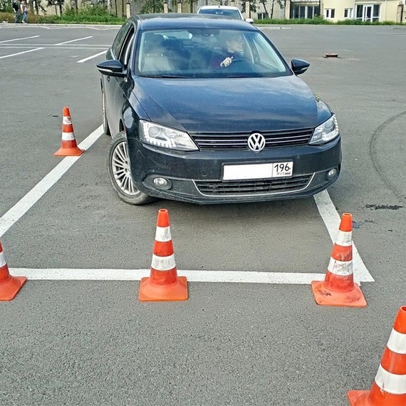 Неправильная парковка автомобиля на стоянке с ограждающими конусами в городских условиях. Фото 10