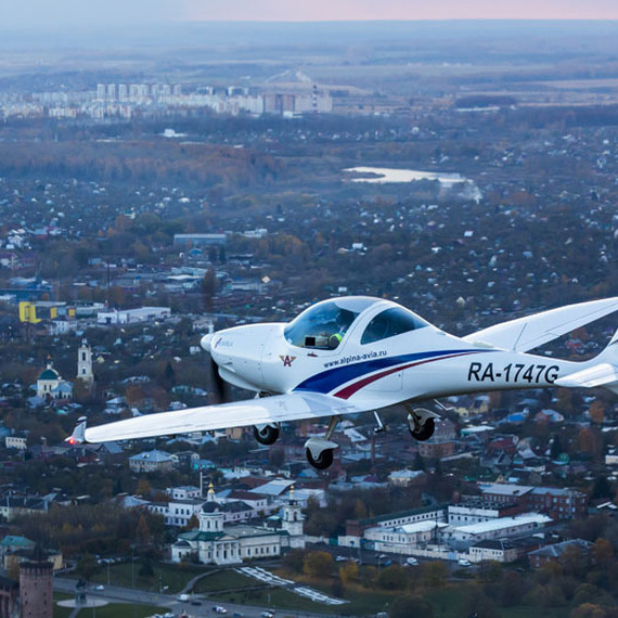 Небо над городом: малый самолет RA-1747G летит над историческим районом на закате. Фото 2