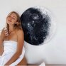 Молодая женщина позирует на фоне картины луны в уютной комнате, наслаждаясь моментом уюта и тишины - превью 1