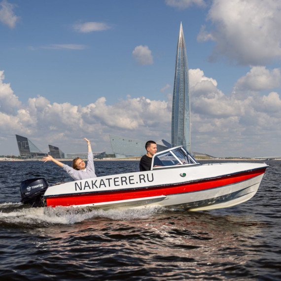 Корабль движется по воде в Санкт-Петербурге с людьми внутри и высокими зданиями на фоне