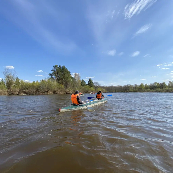 Каякеры на реке в солнечный день с ясным небом Каякеры на реке в солнечный день с ясным небом
