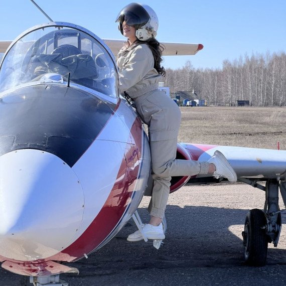 Женщина в комбинезоне на самолете в солнечную погоду