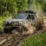 Внедорожник движется по заснеженной дороге в лесу во время зимней гонки - превью 1