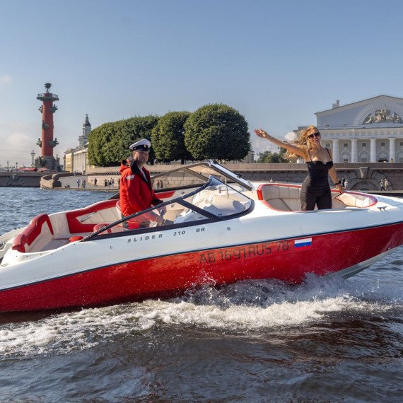 Женщина на моторной лодке приветствует на реке в Санкт-Петербурге