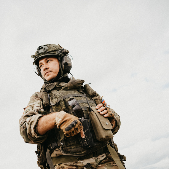 Военный в форме стоит на фоне неба и наблюдает за окружающей обстановкой в условиях выполнения заданий. Фото 34