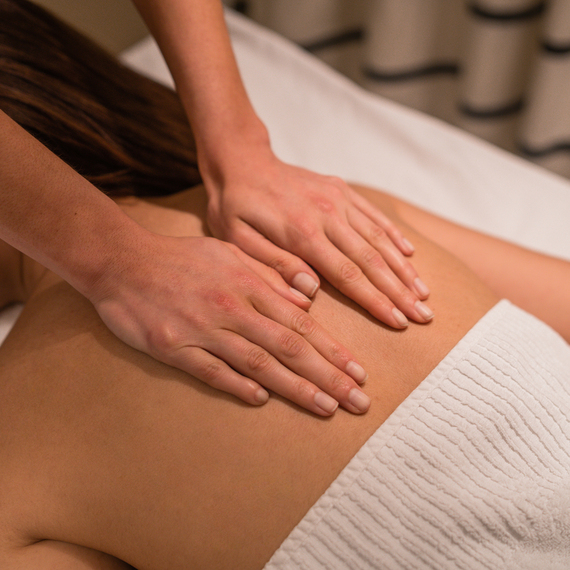 Женщина наслаждается расслабляющей ванной в современном спа-центре при тусклом освещении. Главное фото