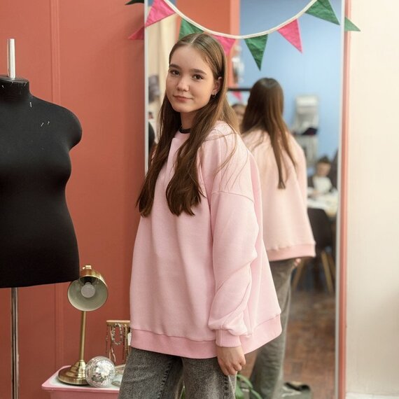 Четыре молодых женщины улыбаются и поднимают большие пальцы вверх в уютном офисе. Главное фото