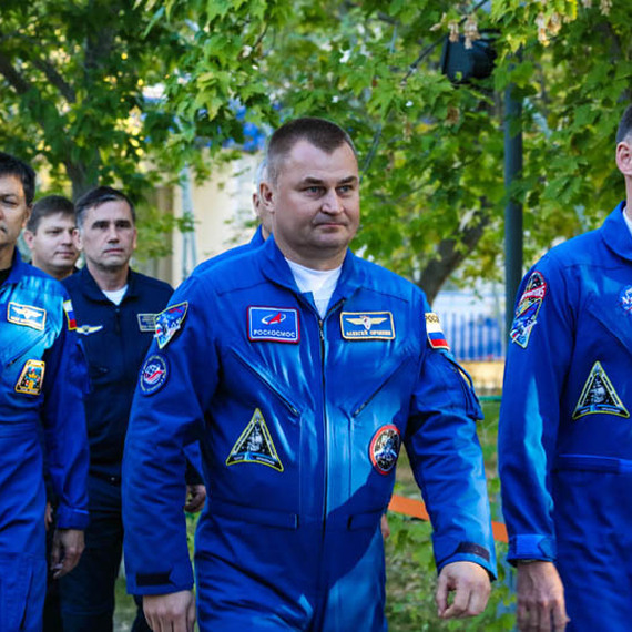 Космонавты в синих комбинизонах идут к ракете на старте в Казахастане в солнечный день. Фото 23