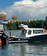 На реке стоит катер KrasBoat 760 у пирса, вдали видны здания и небо с облаками - превью 9
