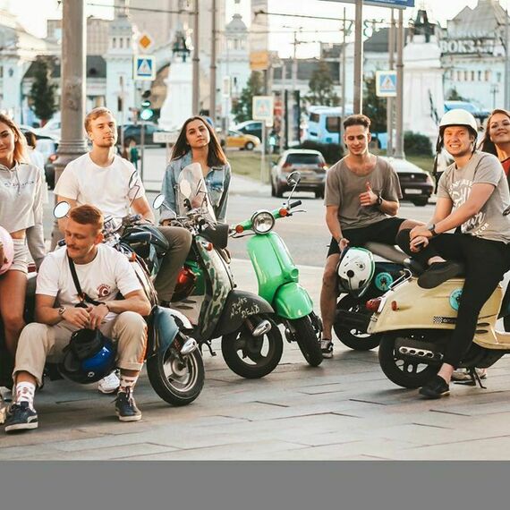 Группа друзей наслаждается прогулкой на электроскутерах в центре города в солнечный день. Фото 4