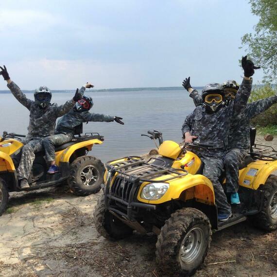 Группа людей на квадроциклах наслаждается дальним отдыхом у водоема в ясный день Группа людей на квадроциклах наслаждается дальним отдыхом у водоема в ясный день