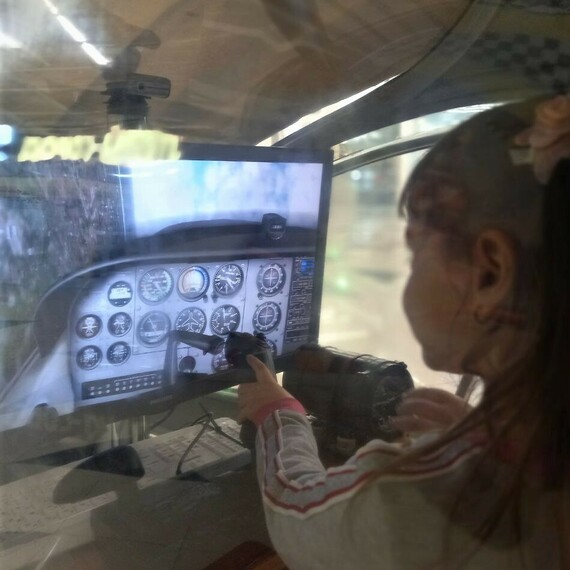 Девочка управляет ави simulation в тренажере в учебном центре в солнечный день. Фото 10