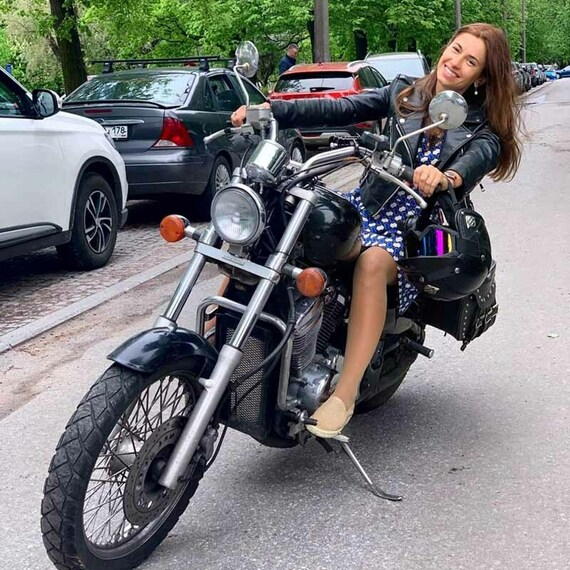 Женщина в кожаной куртке на мотоцикле катается по городскому маршруту в солнечный день. Фото 9