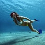 Подводное плавание женщины с ластами в кристально чистой воде тропического моря в солнечный день - превью 1