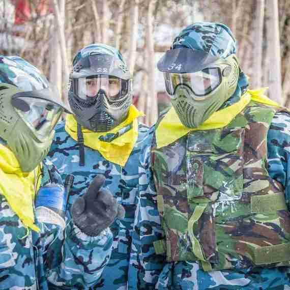 Групповая тренировка команды в камуфляжной экипировке в зимнем лесу, обсуждение стратегии на свежем воздухе. Фото 6