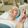 Женщина получает косметическую процедуру в салоне красоты и улыбается - превью 1